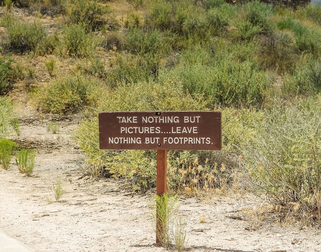 Sign on trail to ancient ruins that says “Take nothing but pictures..leave nothing but footprints “-